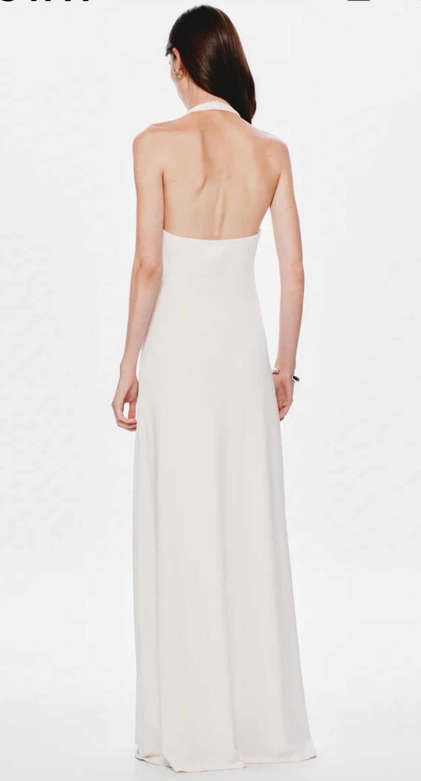 Image shows a model facing away from the camera showing the back of the white Misha Jennifer Cupronickel gown on a white background