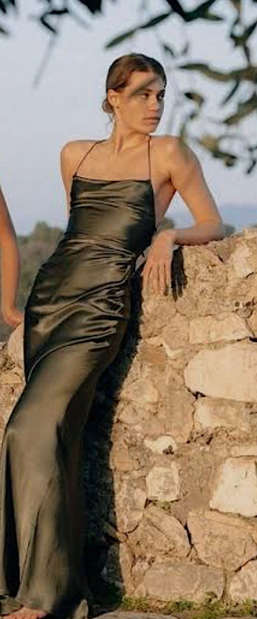 Shona Joy La Lune Lace back dress in Olive modeal leaning against a rock wall