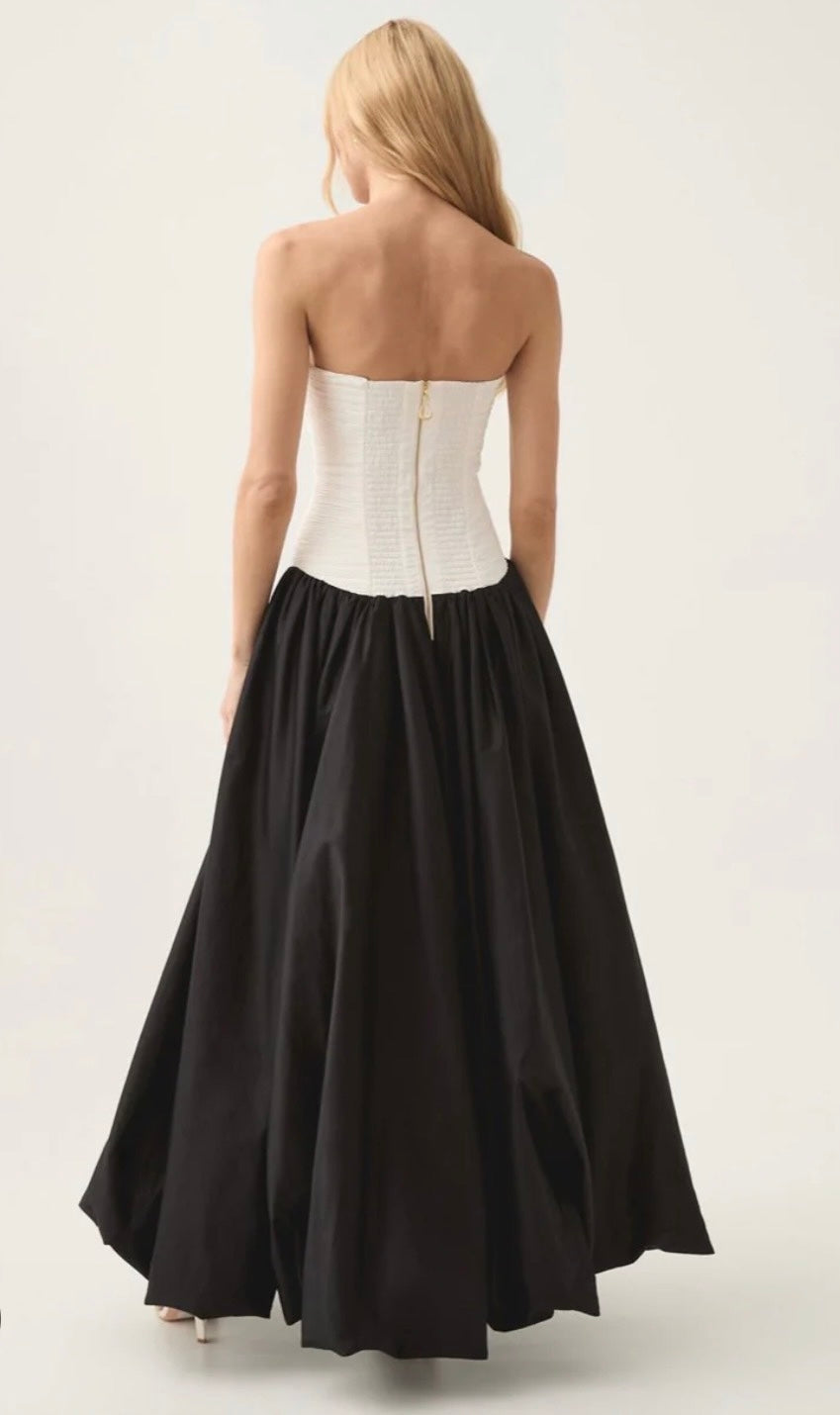 Aje Violette Bubble Hem Dress in Black and White. Model stands facing a white wall and showing the back to the camera. 