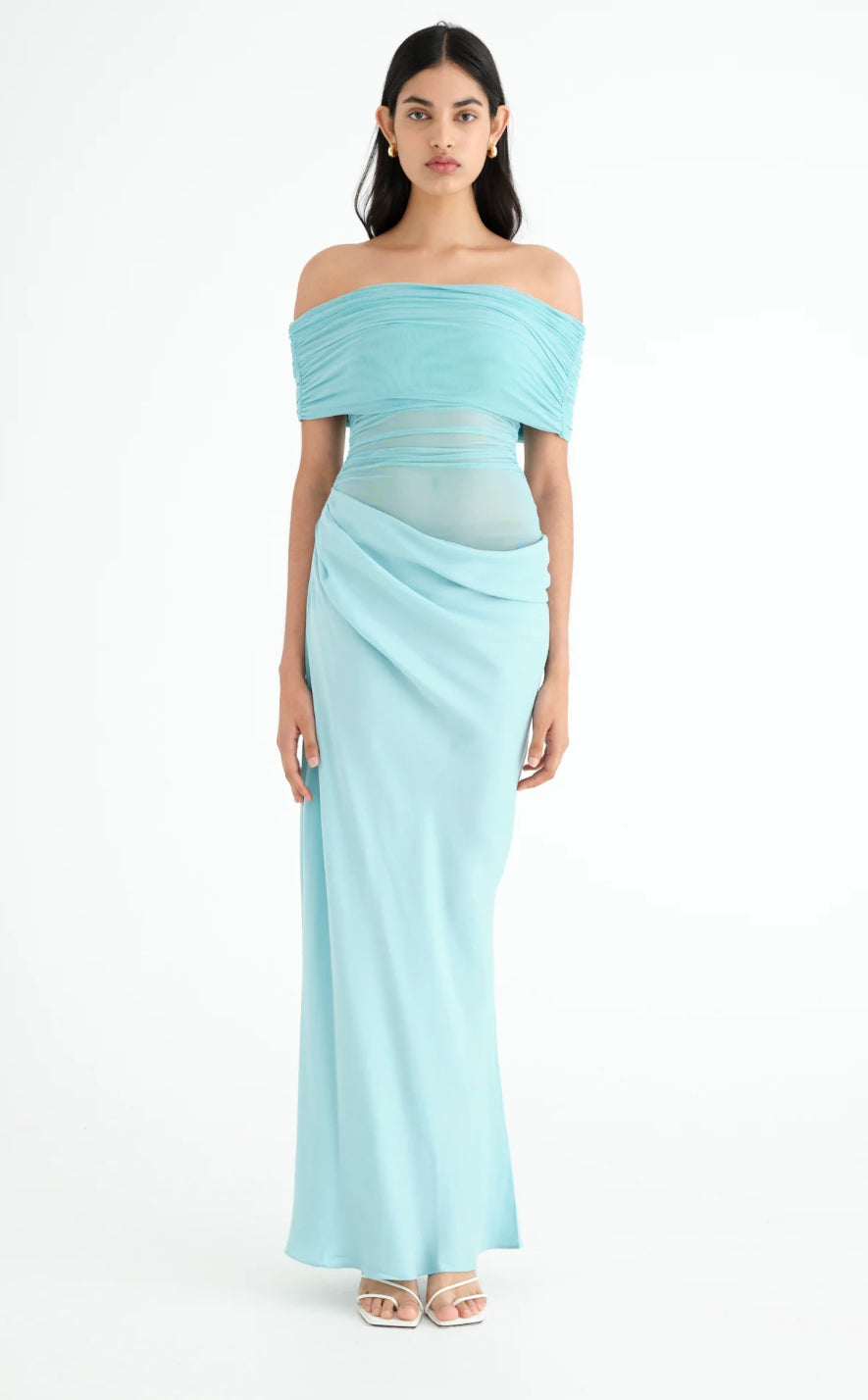 Woman wearing the Benni Nico light blue off-shoulder gown in front of a white background