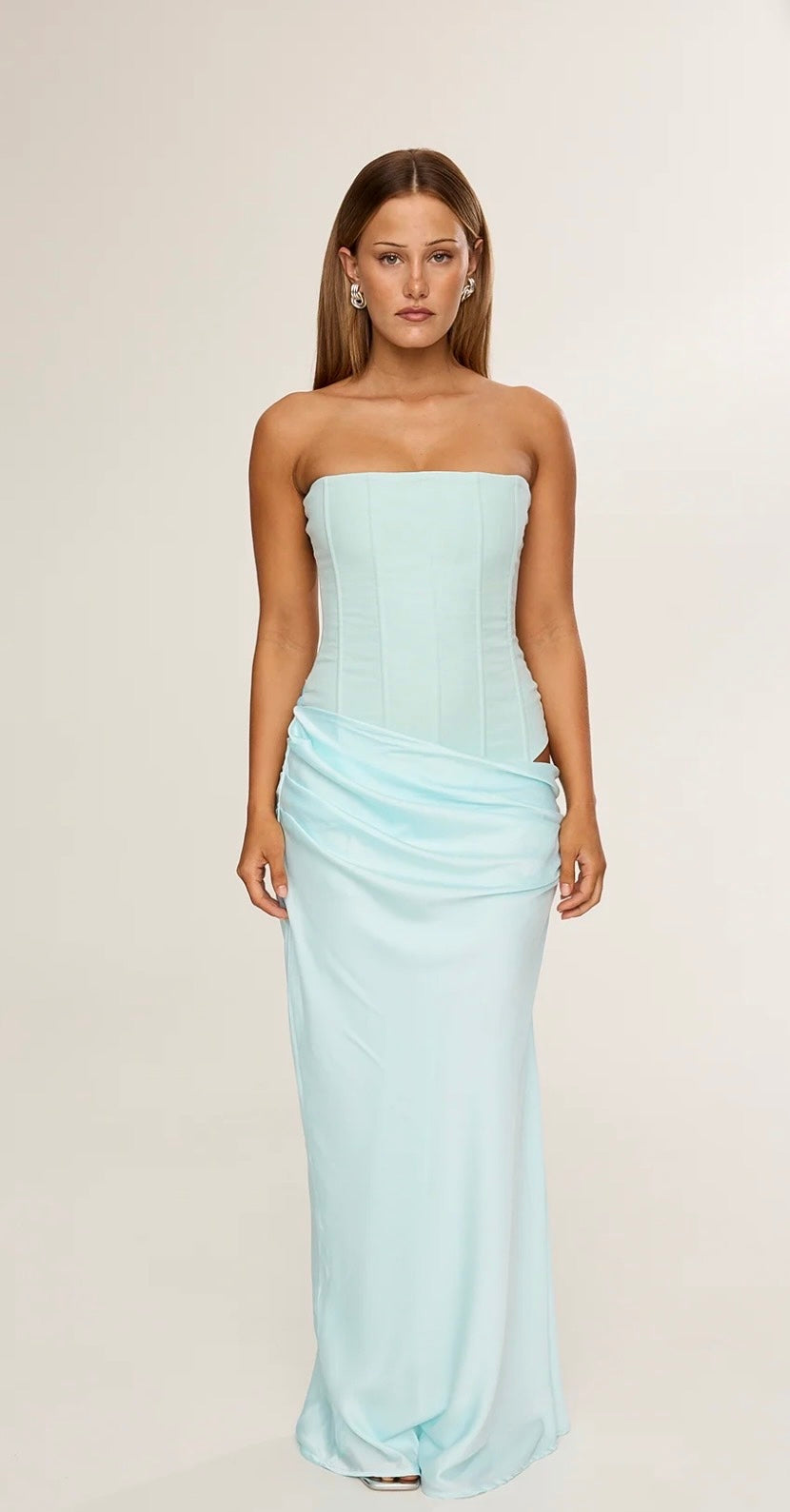 Woman wearing a Hntr the Label Huxley Aqua strapless gown against a plain background