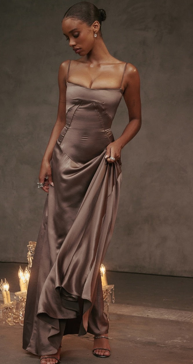 House of CB Anabella Dress in Smoke model looking at the floor with a brown background and chandelier on the floor. 