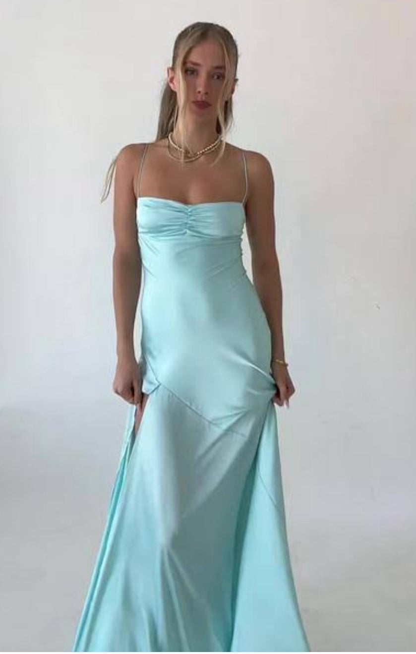 Hntr the Label Gaia Gown in Aqua blue front view with model holding the skirt. 