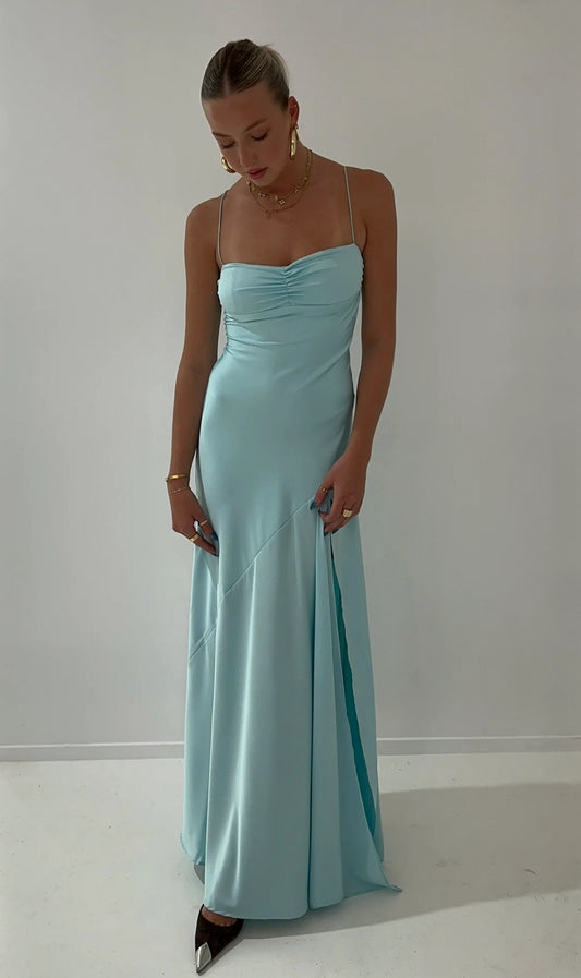 Hntr the Label Gaia Gown in Aqua. Model looking down at the ground with white wall behind. 