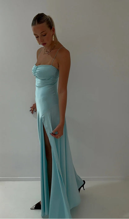 Hntr the Label Gaia Gown in Aqua blue side view showing leg split and midel looking down at the floor.