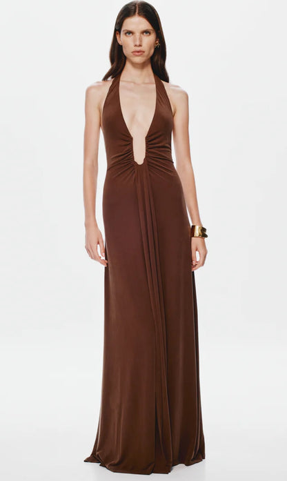 Woman wearing a brown halter neck Misha Jennifer Cupro gown on a white background