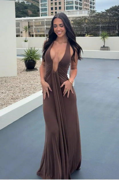 Woman in a brown Misha Jennifer Cupro evening gown standing on a rooftop with buildings in the background