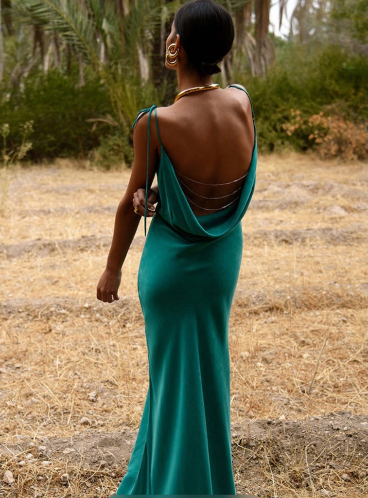 Woman in a Rat and Boa Ophelia green dress standing in a natural setting with trees and dry grass.