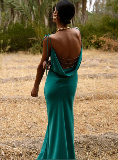 Woman in a Rat and Boa Ophelia green dress standing in a natural setting with trees and dry grass.