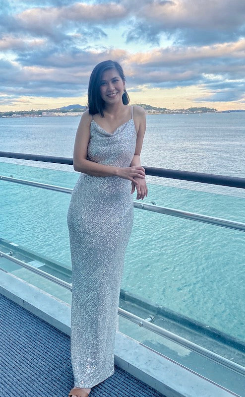 Shona Joy Soiree Silver Sequin Dress Rental shown at the Auckland Hilton overlooking the ocean