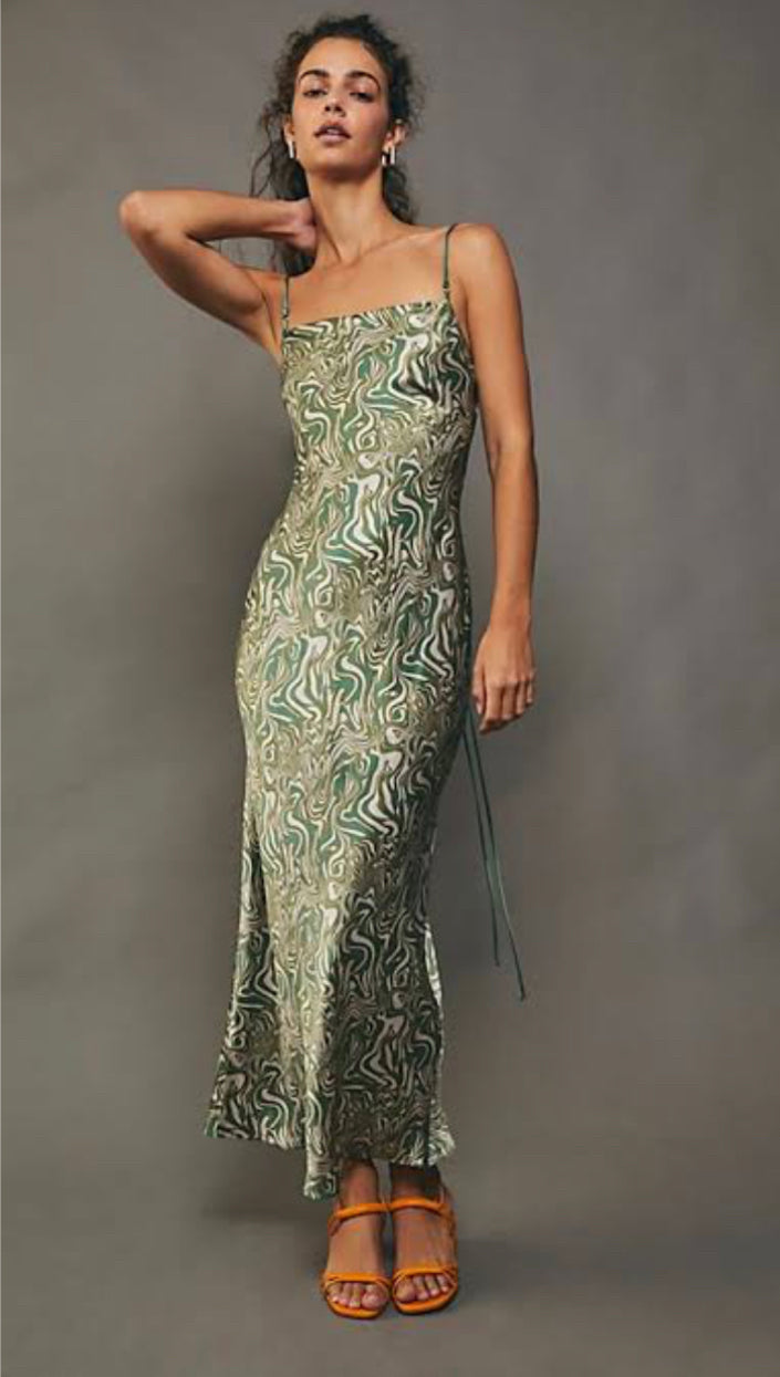 Bec and Bridge Alanis silk maxi dress in green swirl model touching her neck with grey background