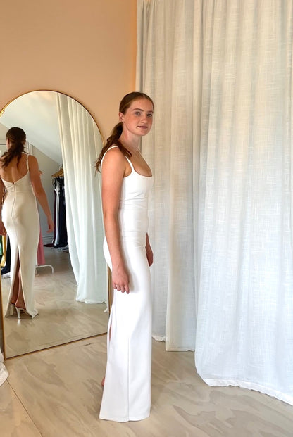 Side view of Nookie Bailey Gown in white model wearing white gown in rental studio Auckland