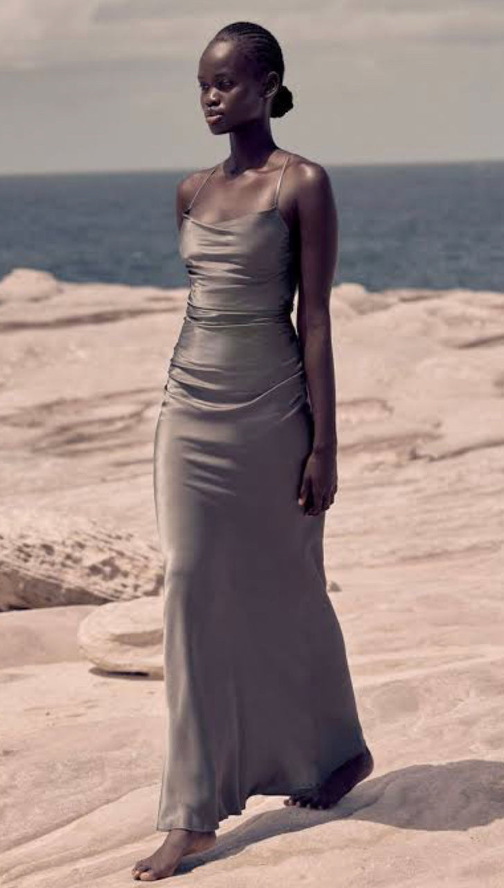Shona Joy La Lune Lace Back Maxi dress in Olive shown on model walking on rocks on a beach 
